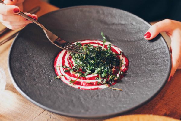 Dettaglio piatto di risotto con mani officina del riso